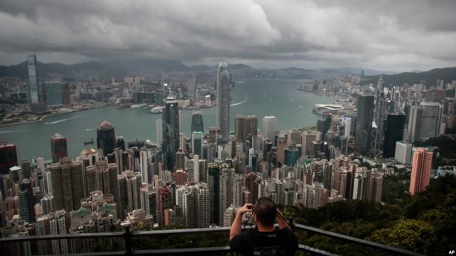 资料照片：一名游客在维多利亚山顶地区架起相机，拍摄香港的天际线。(2019年9月1日)