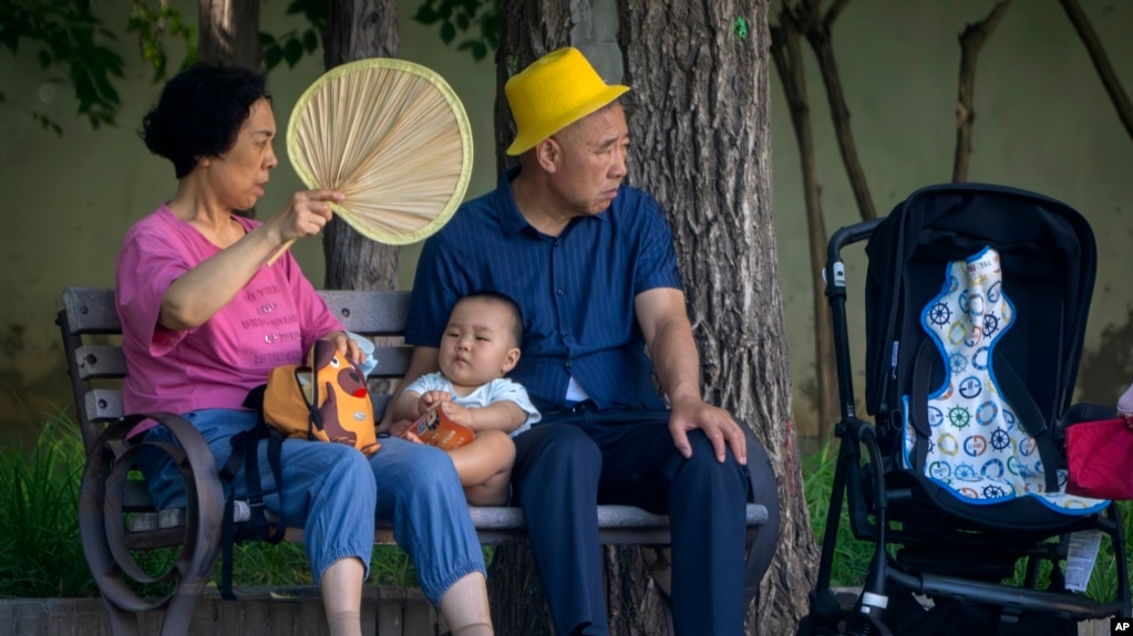 资料照片：北京公园里一对老夫妇和一名幼儿在乘凉。（2023年6月29日）