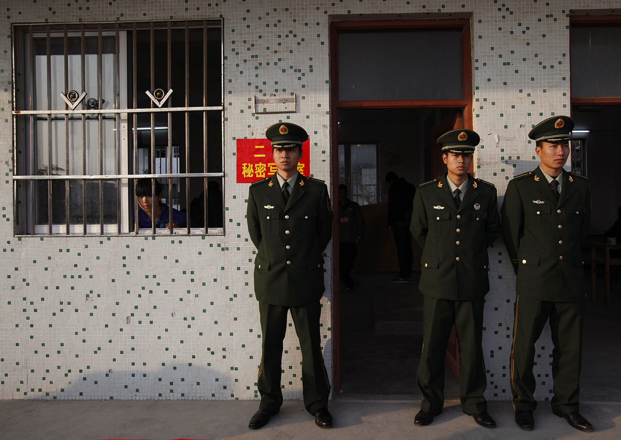 2012年2月1日的一次地方选举过后，广东省陆丰市乌坎村的警察在一处由学校教室改设的计票所外面站岗。(路透社资料图片)