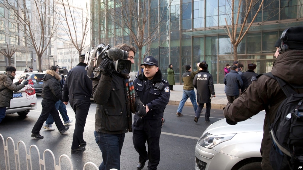 资料照片：中国政府加大对外国记者的压制。图为2014年1月26日，警察阻止在北京的外国记者采访受审的法律维权人士许志永的辩护律师张庆方。