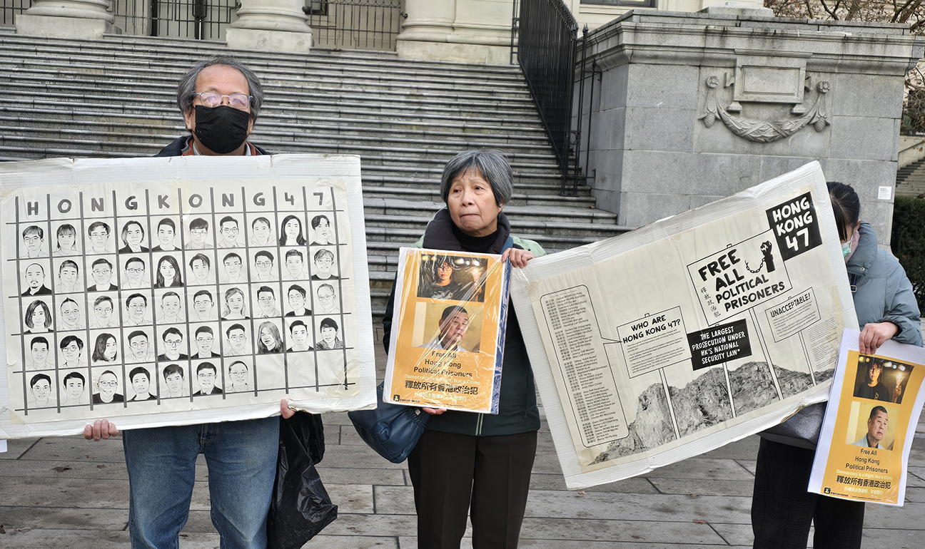 民众拿着四十七名个民主派骨干分子的头像和事件说明图板，向街头路人说明四十七人案的意义。  (记者柳飞拍摄)